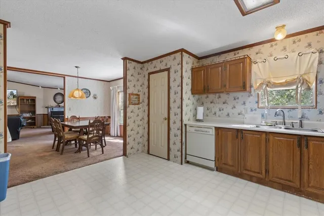 a dining room with stainless steel appliances kitchen island granite countertop furniture and a window