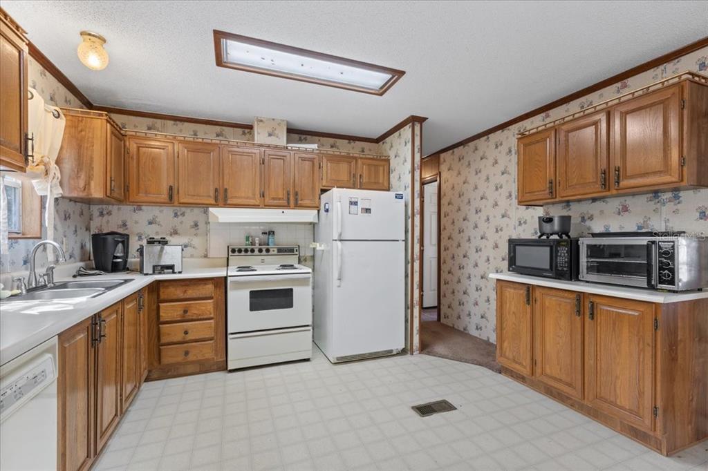 4945 Southwest Highway 358 Steinhatchee, FL 32359 - Photo 8 of 35 a kitchen with stainless steel appliances granite countertop a refrigerator sink a stove and oven