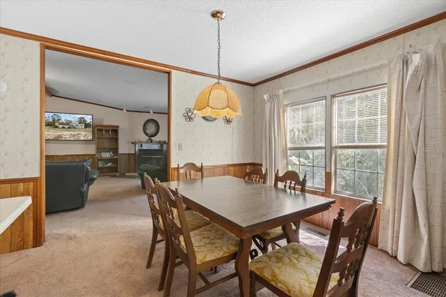 a dining room with furniture a chandelier and window