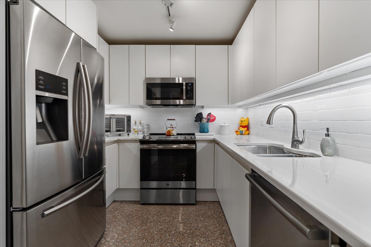 200 East Delaware Place, Unit 13C Chicago, IL 60611 - Photo 16 of 31 a kitchen with stainless steel appliances a sink cabinets and a refrigerator