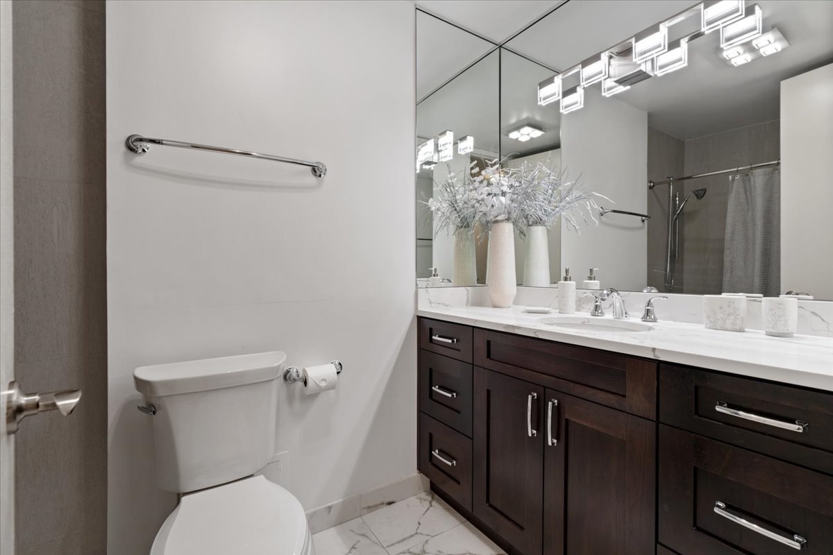 200 East Delaware Place, Unit 13C Chicago, IL 60611 - Photo 22 of 31 a bathroom with a sink a toilet and a mirror