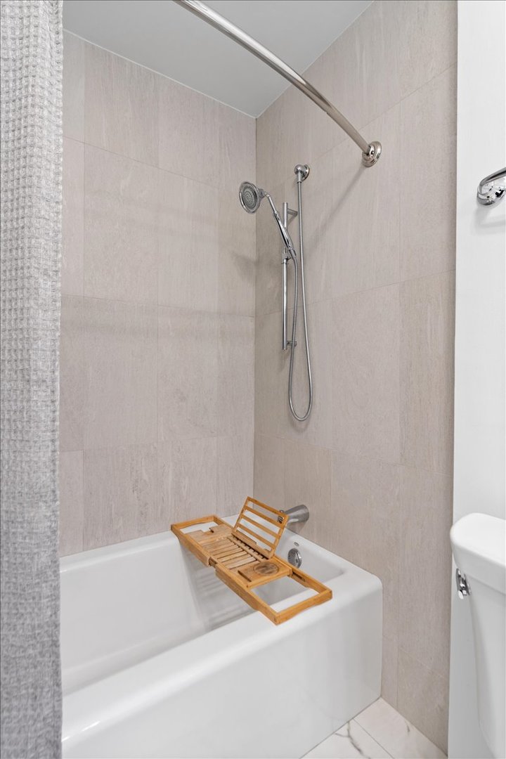 200 East Delaware Place, Unit 13C Chicago, IL 60611 - Photo 23 of 31 a bathroom with a sink a bath tub and a shower