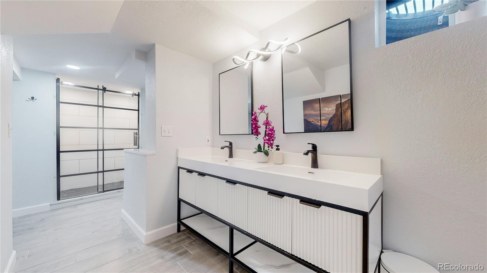 9420 Ridge Road Arvada, CO 80002 - Photo 15 of 31 a bathroom with a sink double vanity and a mirror
