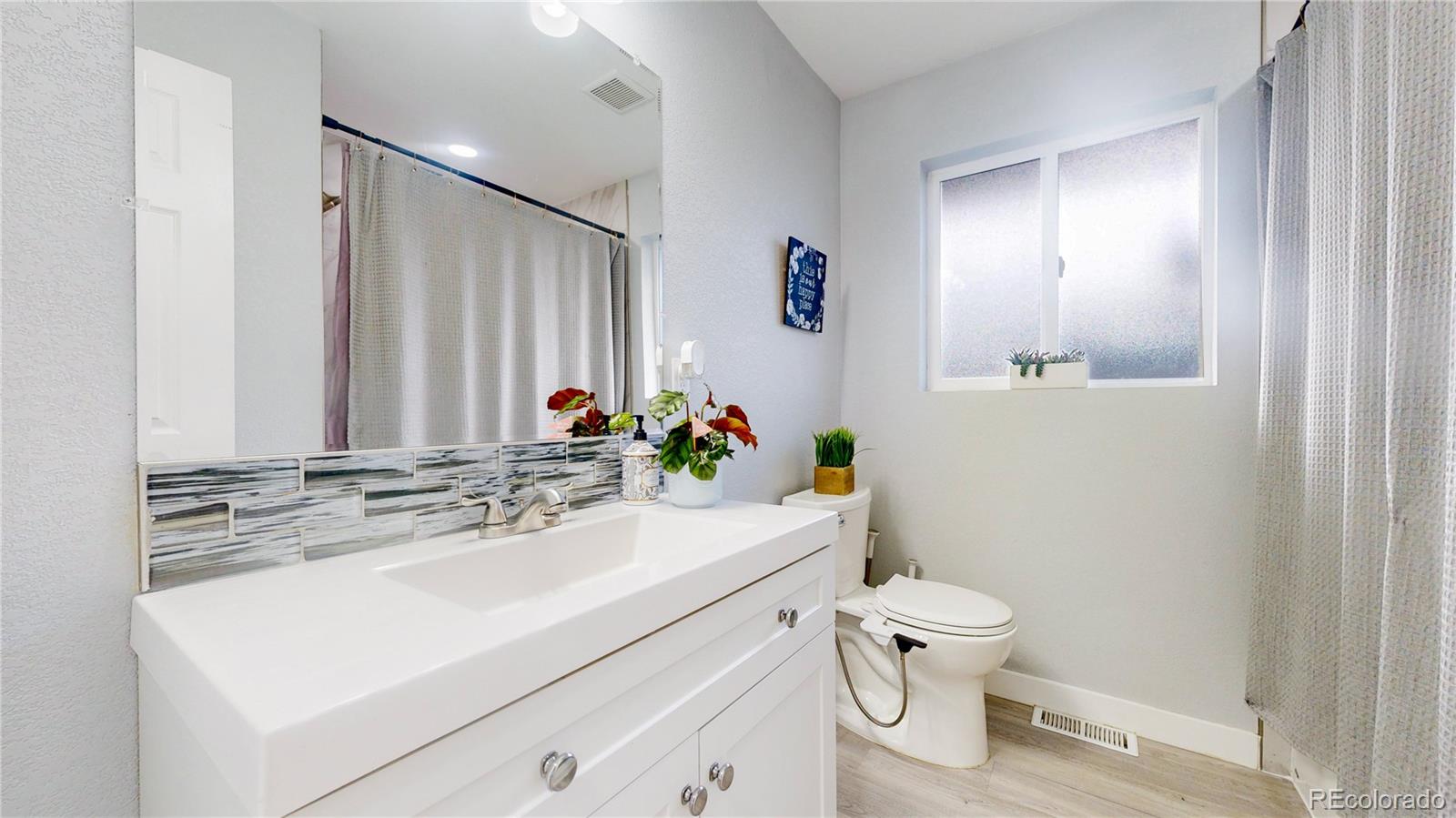 9420 Ridge Road Arvada, CO 80002 - Photo 16 of 31 a bathroom with a sink toilet vanity and mirror