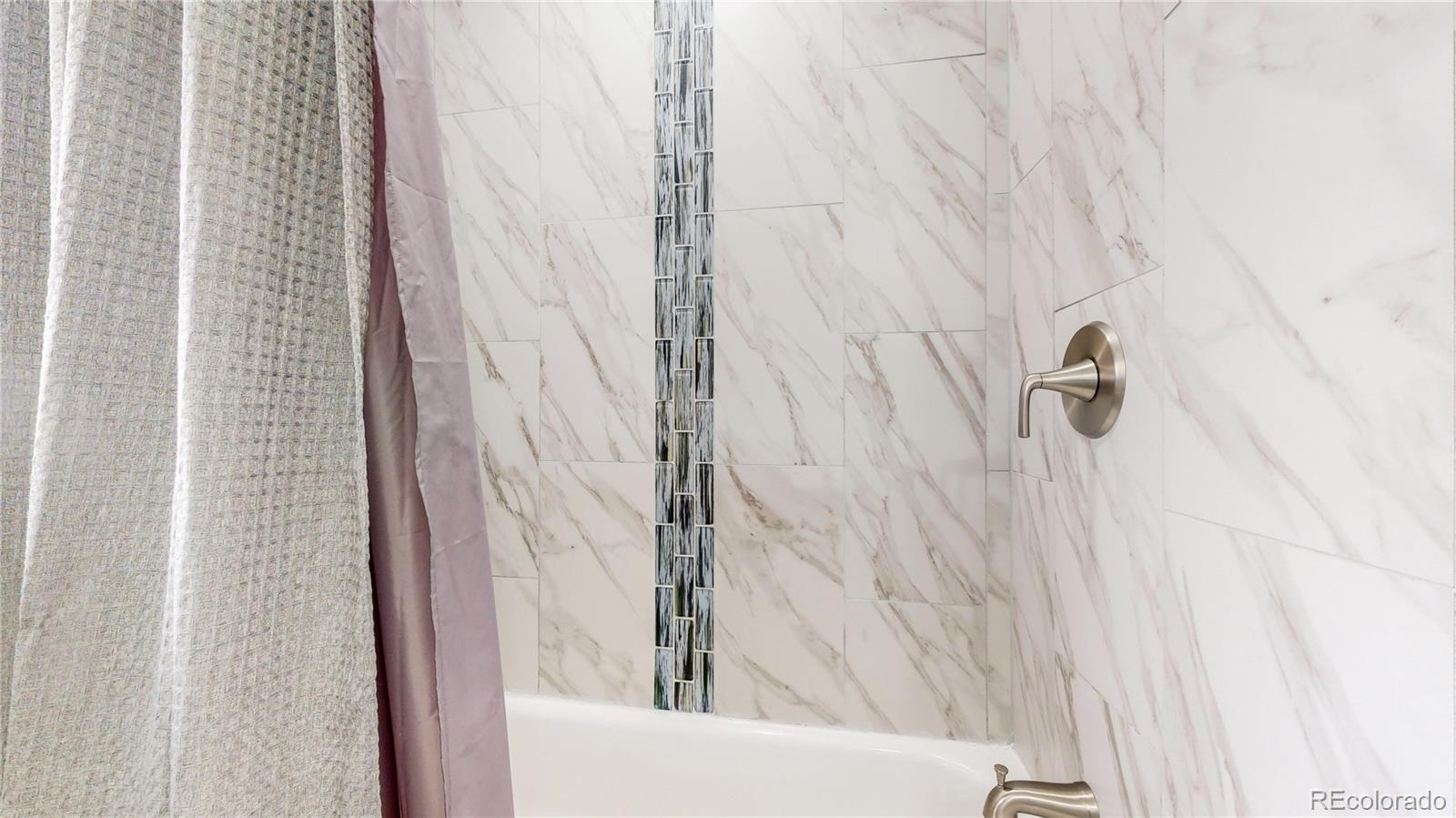 9420 Ridge Road Arvada, CO 80002 - Photo 17 of 31 a bathroom with a shower curtain