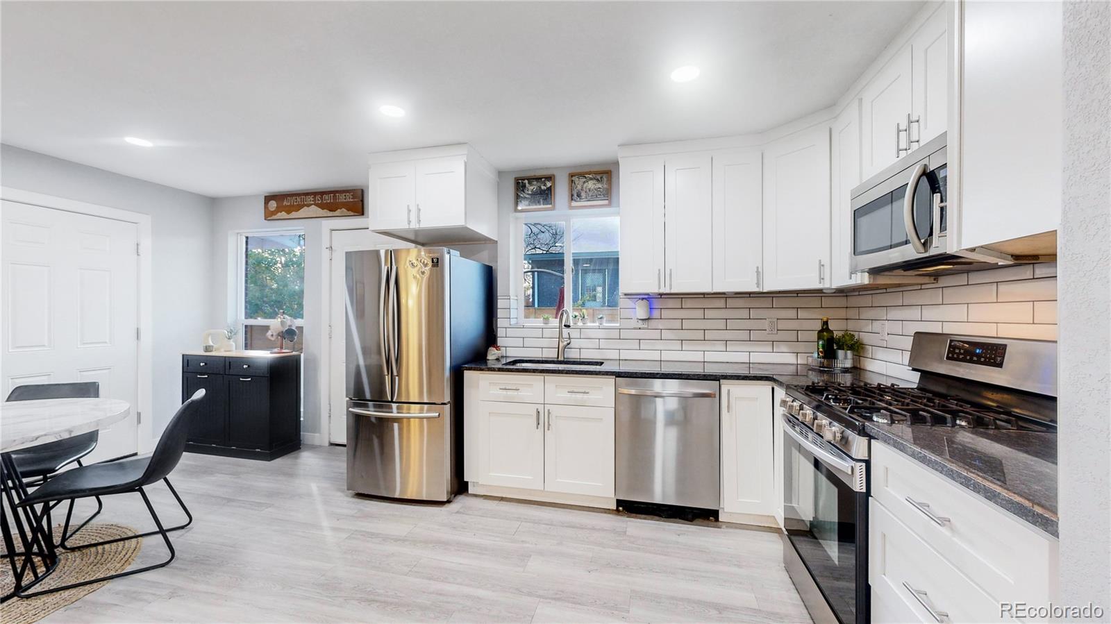 9420 Ridge Road Arvada, CO 80002 - Photo 4 of 31 a kitchen with stainless steel appliances granite countertop a refrigerator a stove and a sink