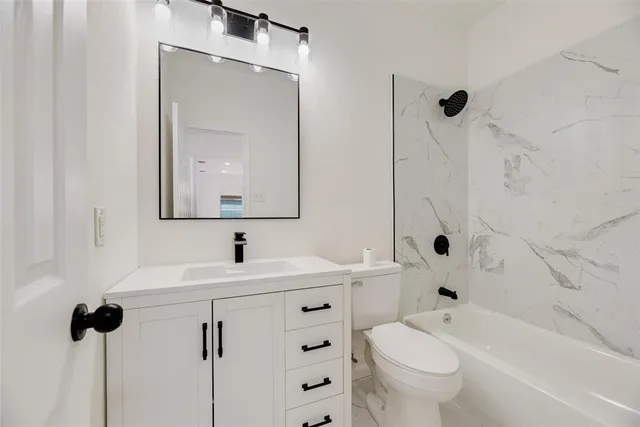 a bathroom with a sink mirror toilet and bathtub