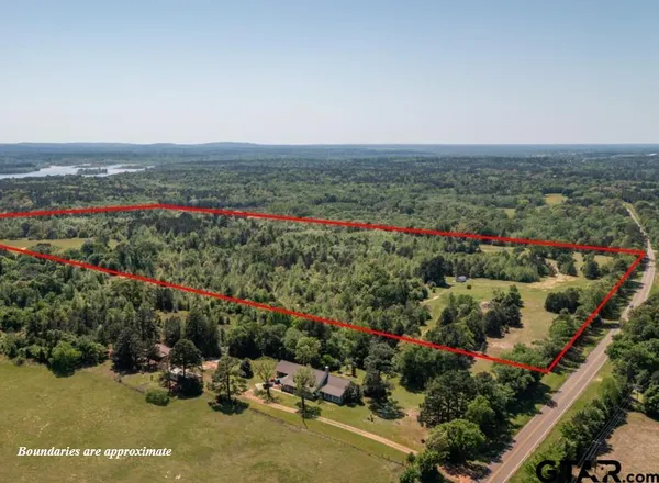 an aerial view of a houses with a yard and lake view