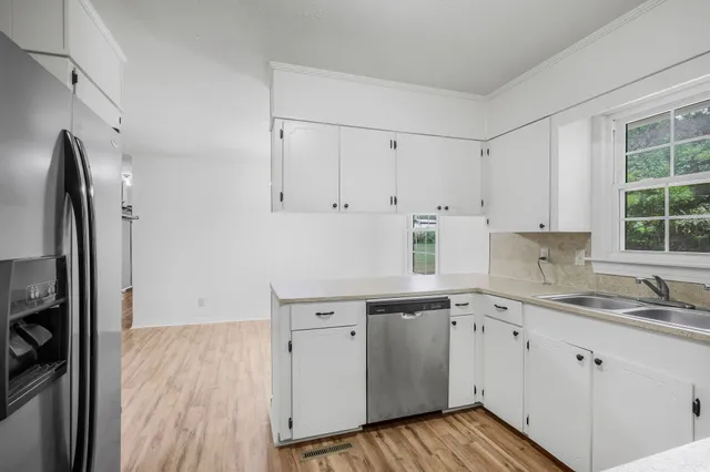 a kitchen with granite countertop white cabinets and white appliances