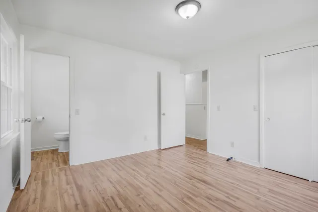a view of a room with wooden floor and a bathroom
