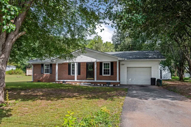 a front view of a house with yard and green space