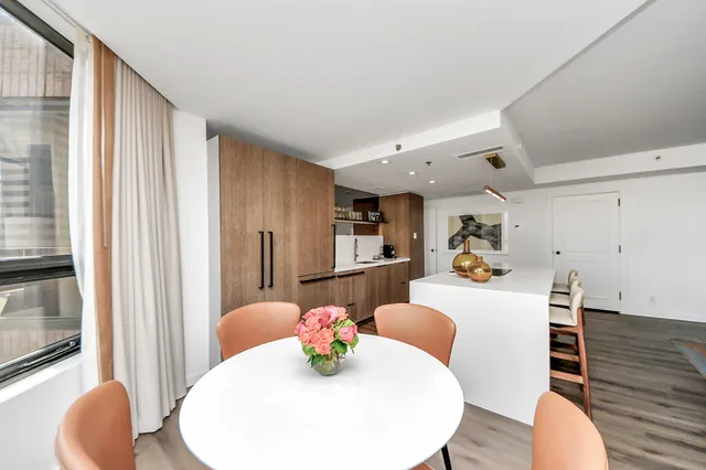 a large white kitchen with furniture and wooden floor