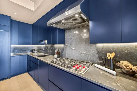 a open kitchen with a stove a kitchen island a stove and a wooden floors