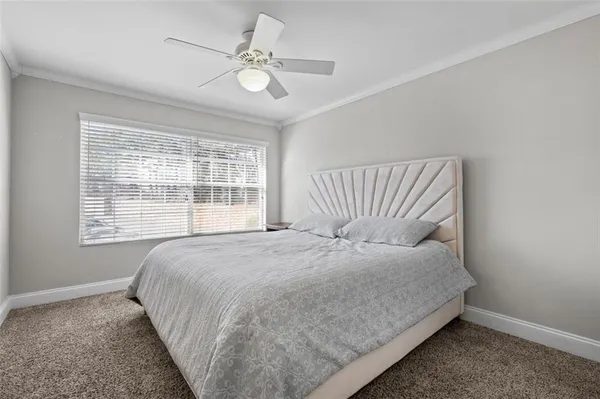 a large bed sitting in a bedroom next to a window