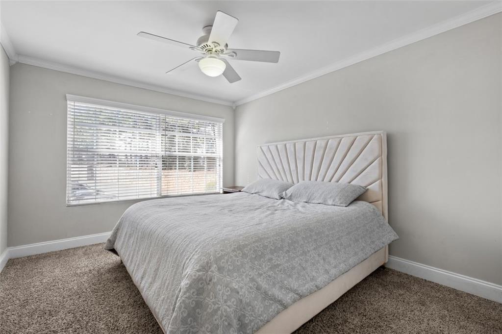 6980 Roswell Road, Unit A8 Atlanta, GA 30328 - Photo 13 of 26 a large bed sitting in a bedroom next to a window