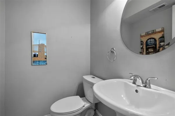 a bathroom with a toilet a sink and mirror
