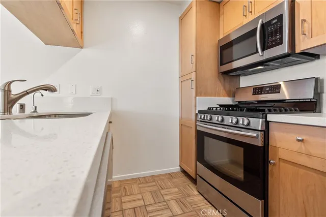 a kitchen with stainless steel appliances granite countertop a stove microwave and sink