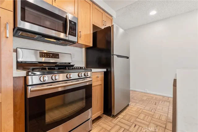 a kitchen with stainless steel appliances granite countertop a stove microwave and refrigerator