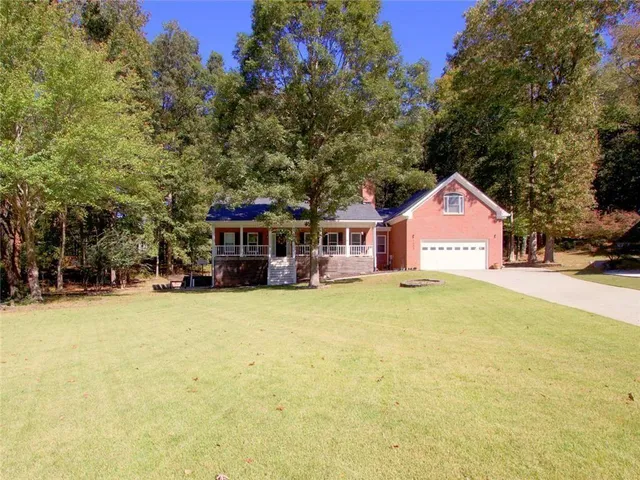a front view of a house with yard and trees