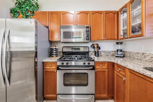 a kitchen with granite countertop sink and wooden cabinets