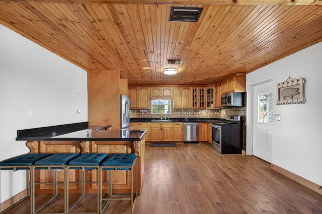 a kitchen with stainless steel appliances granite countertop a sink a stove and refrigerator