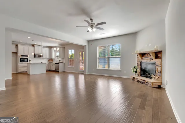 a view of a livingroom with furniture wooden floor and a kitchen