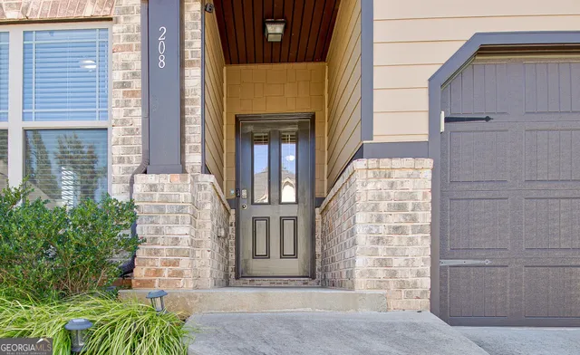 a view of front door of house with potted plants