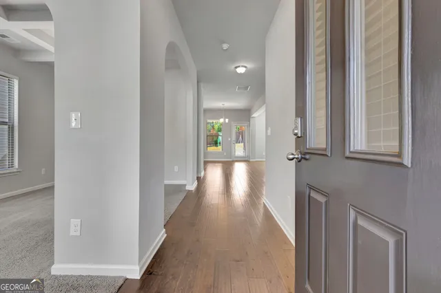 a view of a hallway with wooden floor and staircase