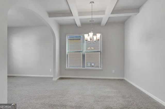 an empty room with windows and chandelier