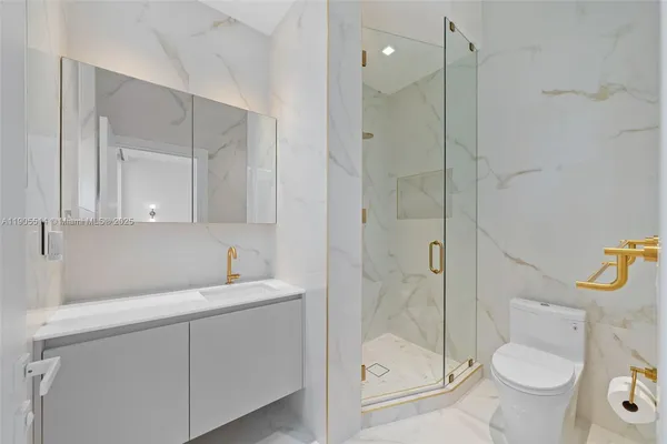 a bathroom with a granite countertop sink toilet and shower