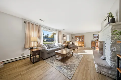 a living room with fireplace furniture and a large window