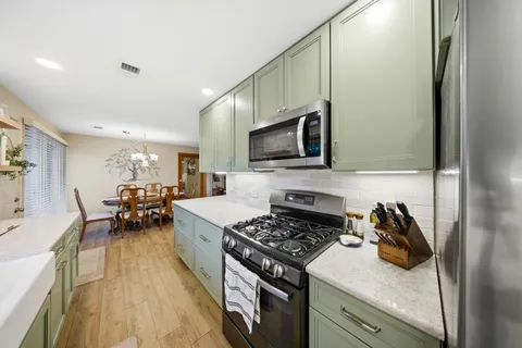 a kitchen with sink a stove and cabinets