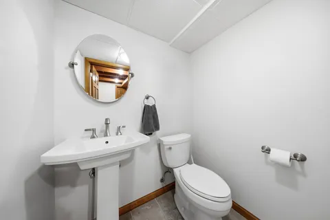 a bathroom with a toilet a sink and mirror