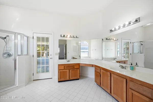 a large white kitchen with a large window and stainless steel appliances