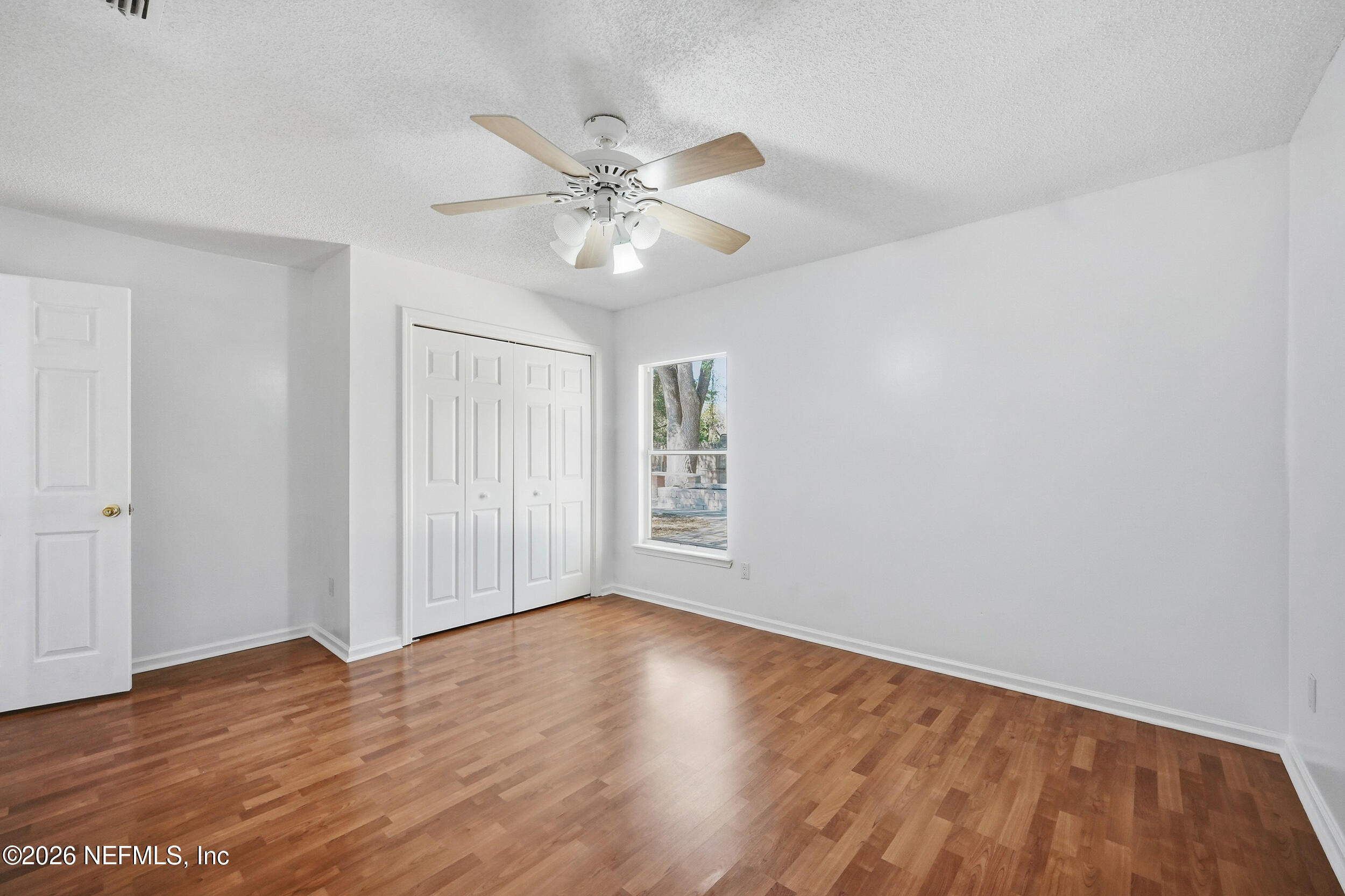 5019 Ripple Rush Drive North Jacksonville, FL 32257 - Photo 17 of 40 a view of an empty room with wooden floor and a window