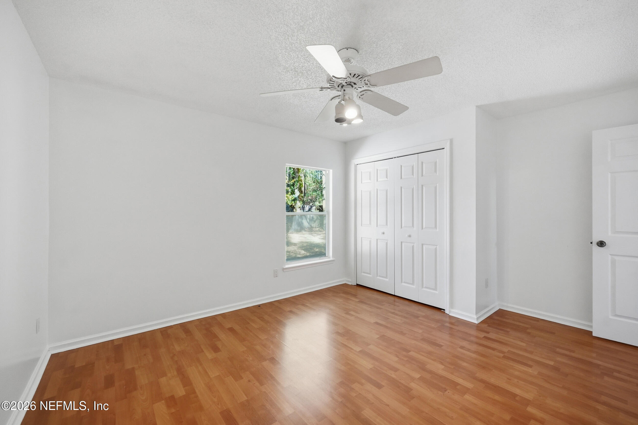 5019 Ripple Rush Drive North Jacksonville, FL 32257 - Photo 18 of 40 an empty room with wooden floor fan and windows