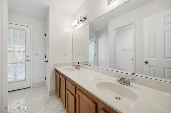 a bathroom with a double vanity sink a mirror and a shower