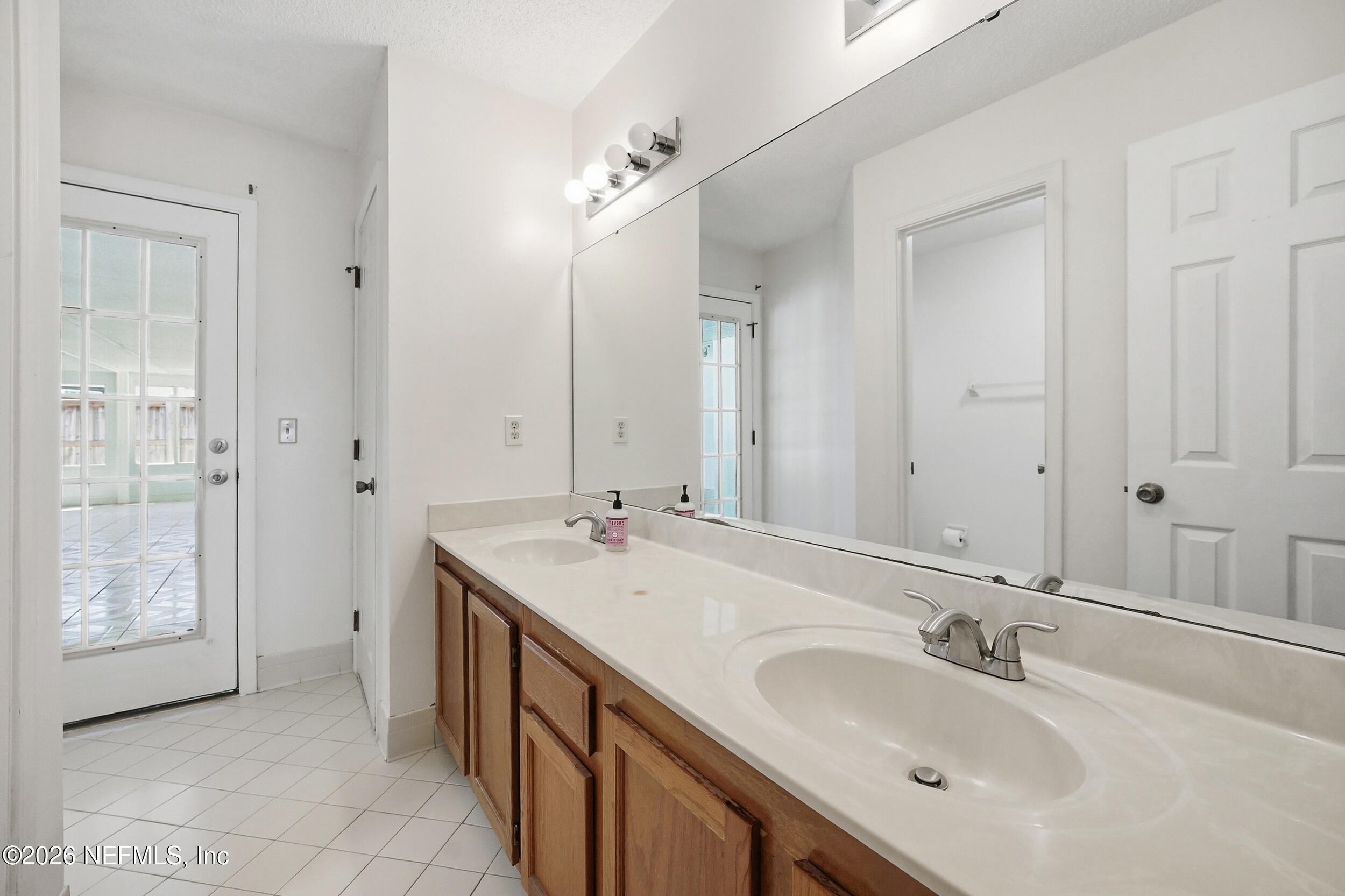 5019 Ripple Rush Drive North Jacksonville, FL 32257 - Photo 20 of 40 a bathroom with a double vanity sink a mirror and a shower