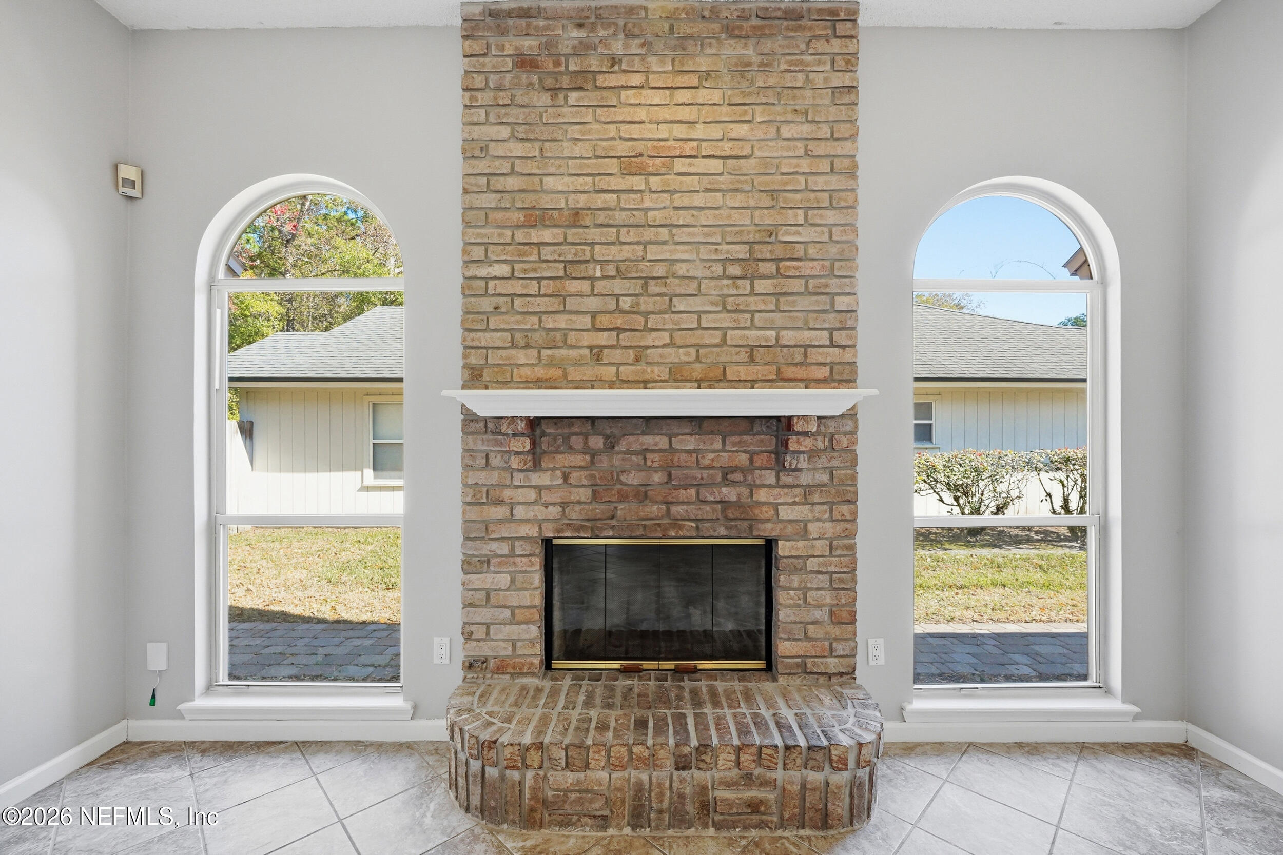 5019 Ripple Rush Drive North Jacksonville, FL 32257 - Photo 29 of 40 a front view of a house with a fireplace a potted plant and a large window