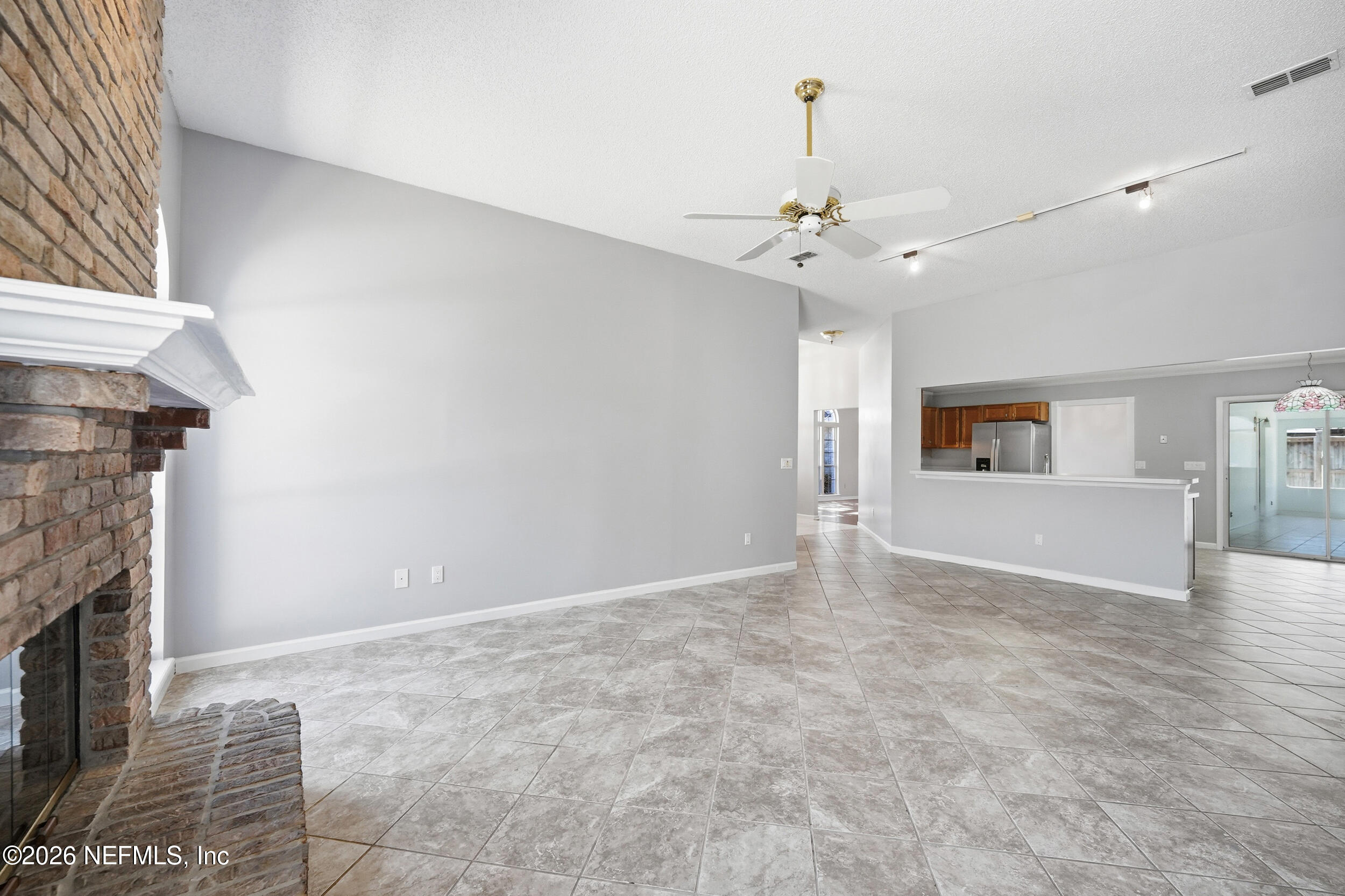 5019 Ripple Rush Drive North Jacksonville, FL 32257 - Photo 30 of 40 a view of an empty room with chandelier fan and fireplace