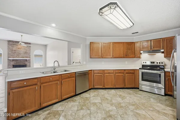 a kitchen with stainless steel appliances granite countertop a stove sink and cabinets