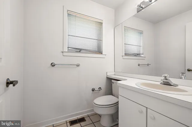 a bathroom with a sink a toilet and mirror