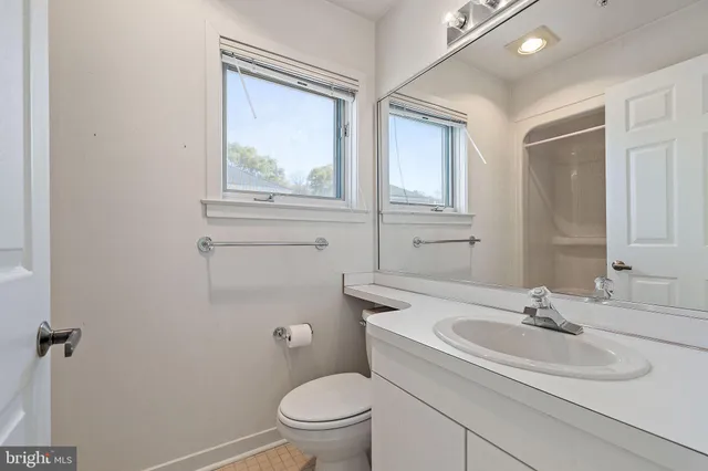 a bathroom with a sink a toilet and a window