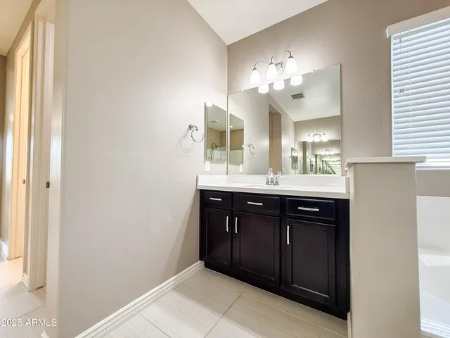 a bathroom with a sink vanity and a mirror