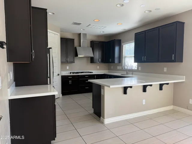 a kitchen with stainless steel appliances granite countertop a stove a sink and a refrigerator