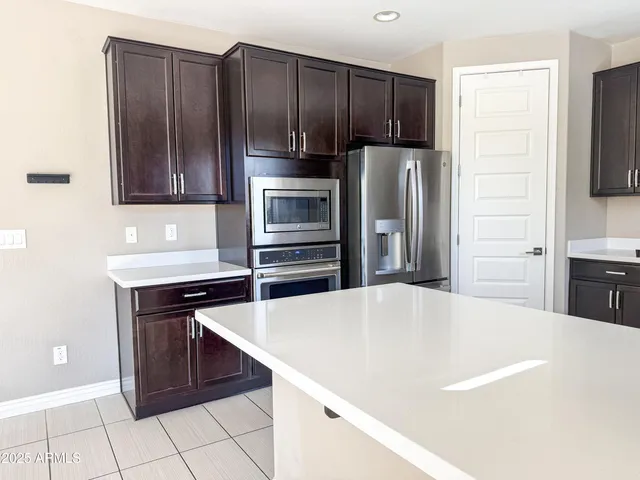 a kitchen with kitchen island a refrigerator and a stove top oven