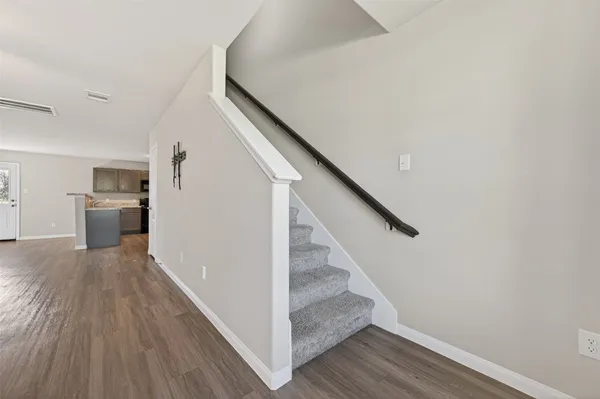 a view of a hallway with wooden floor and staircase