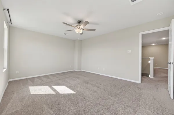 an empty room with fan and windows