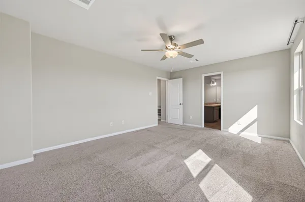 a view of an empty room with chandelier fan