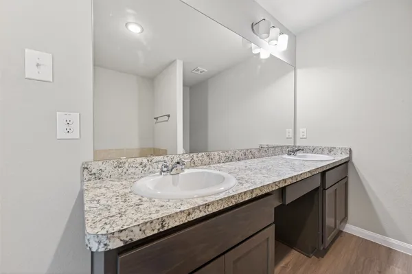 a bathroom with a granite countertop sink a large mirror and vanity